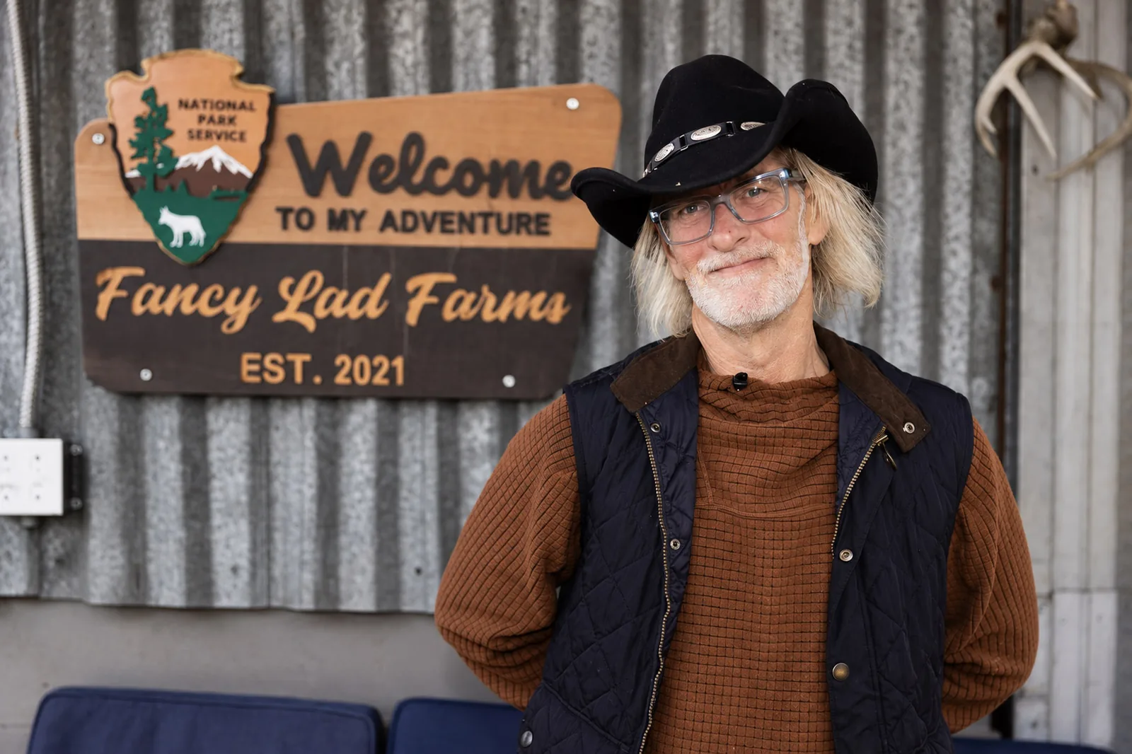 Todd stands in front of the hand-painted Fancy Lad Farms sign at his wildlife sanctuary in Old Mines, Missouri.