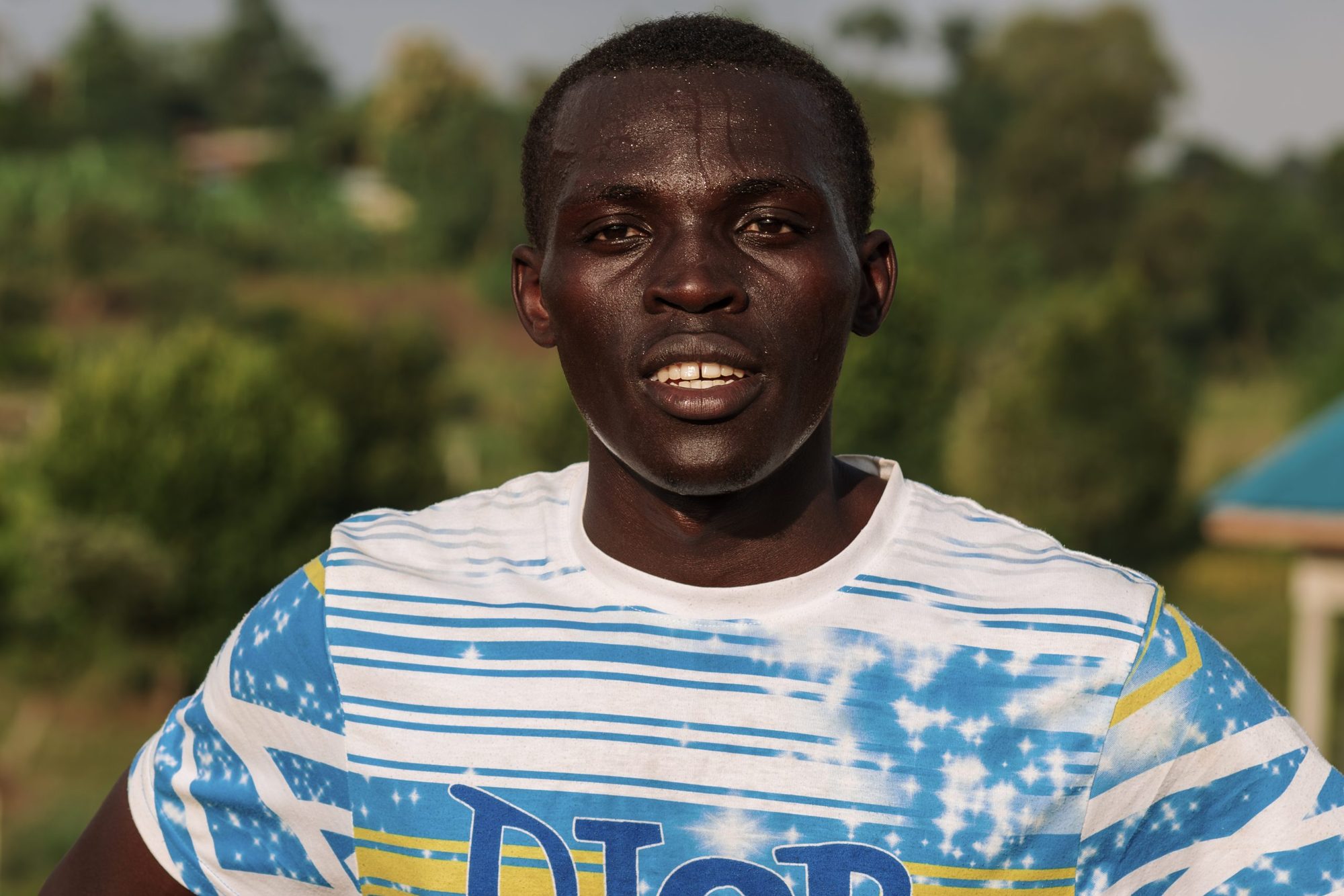 A young farmer photographed at golden hour in rural Uganda